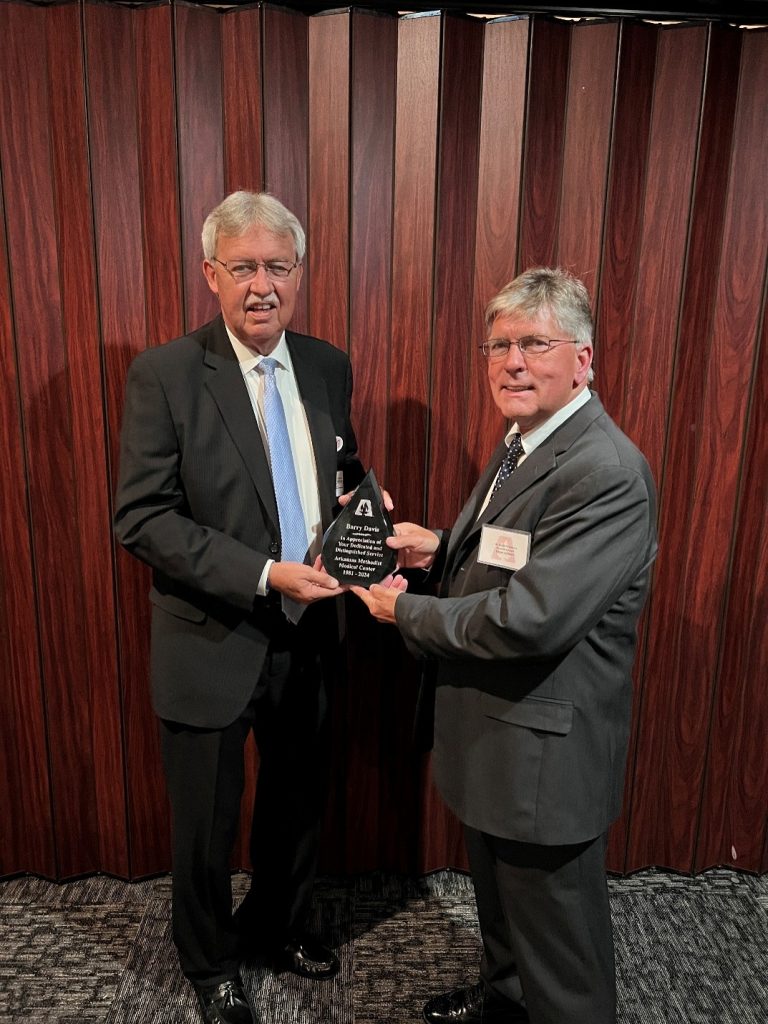 2 men posing with an award