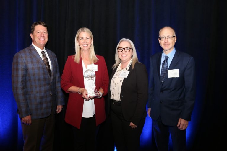 A group posing with an award
